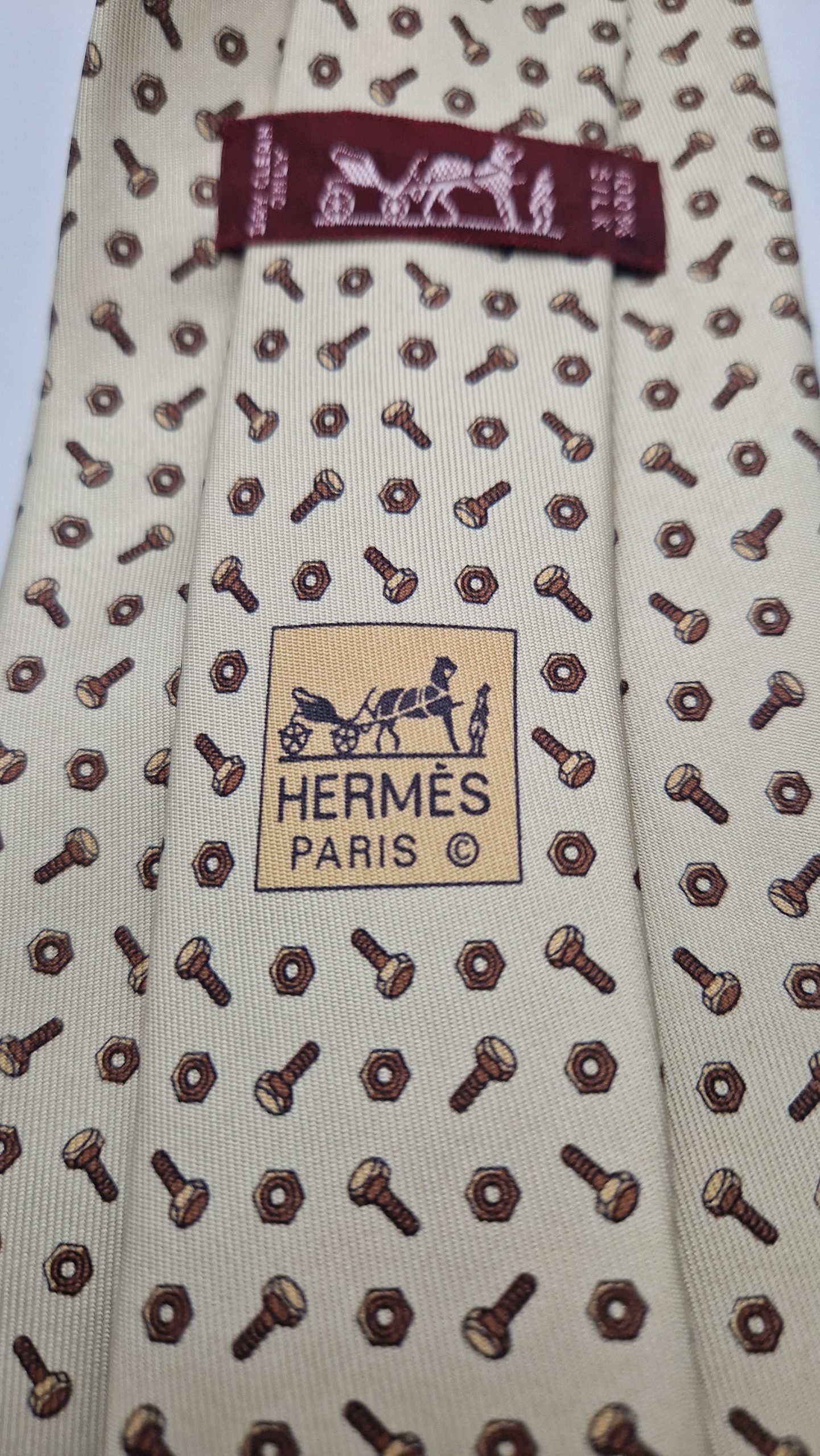 Superbe cravate vintage motifs boulons Parfait état Largeur 9 cm 100 % soie Fabriqué en France Couleur de base : blanc cassé