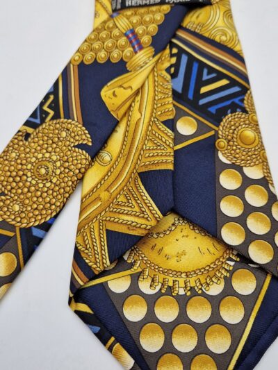 Magnifique cravate Hermès d'après le carré  Hermès L 'or des chefs  dessiné  par Joachim Metz en 1997. Thème traditions africaines.