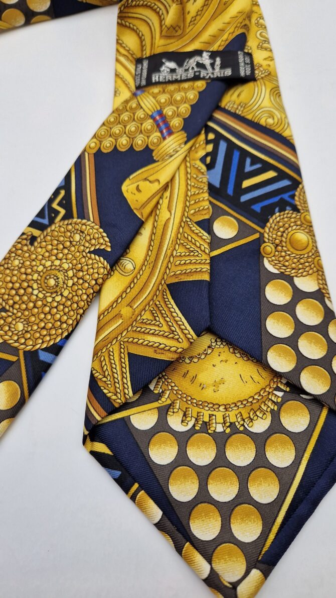 Magnifique cravate Hermès d'après le carré  Hermès L 'or des chefs  dessiné  par Joachim Metz en 1997. Thème traditions africaines.
