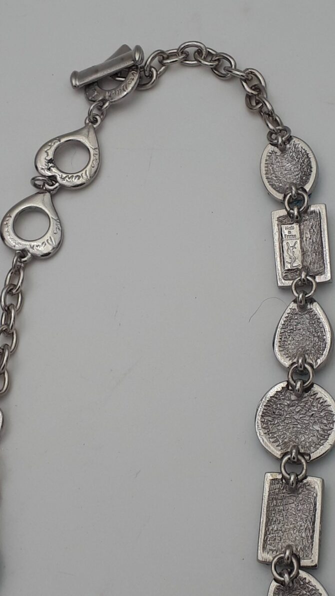 Très joli collier Yves Saint Laurent en métal argenté et strass , il est en parfait état Mesures : le collier mesure 46 cm de long Signé YSL made in France