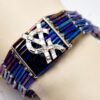 Bracelet Yves Saint Laurent en perles, strass et métal argenté