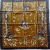 Carré Hermès en soie intitulé "Les Écureuils" de Xavier de Poret, édition de 1966, représentant des écureuils gris dessinés avec réalisme parmi des feuilles de chêne et des noisettes sur fond brun doré, bordé de noir.