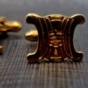 Boutons de manchette Céline dorés, motif Triomphe en relief.