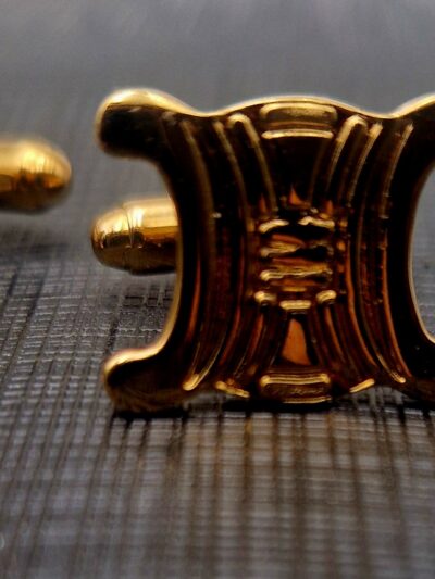 Boutons de manchette Céline dorés, motif Triomphe en relief.
