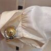 gros plan d'un bouton avec la gravure celine paris porté sur une chemise en soie