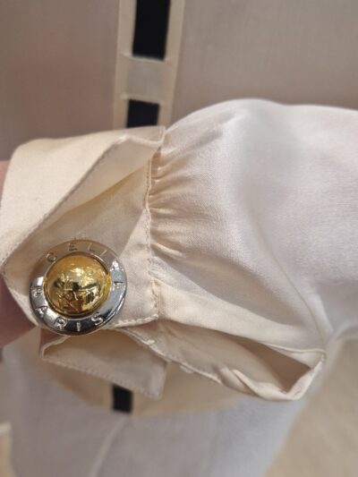 gros plan d'un bouton avec la gravure celine paris porté sur une chemise en soie