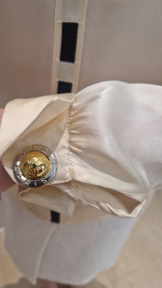 gros plan d'un bouton avec la gravure celine paris porté sur une chemise en soie