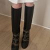 Bottes Chanel en cuir noir matelassé avec chaînes dorées et logo CC – Chanel black quilted leather boots with gold chains and CC charm.