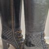 Bottes Chanel en cuir noir matelassé avec chaînes dorées et logo CC – Chanel black quilted leather boots with gold chains and CC charm.