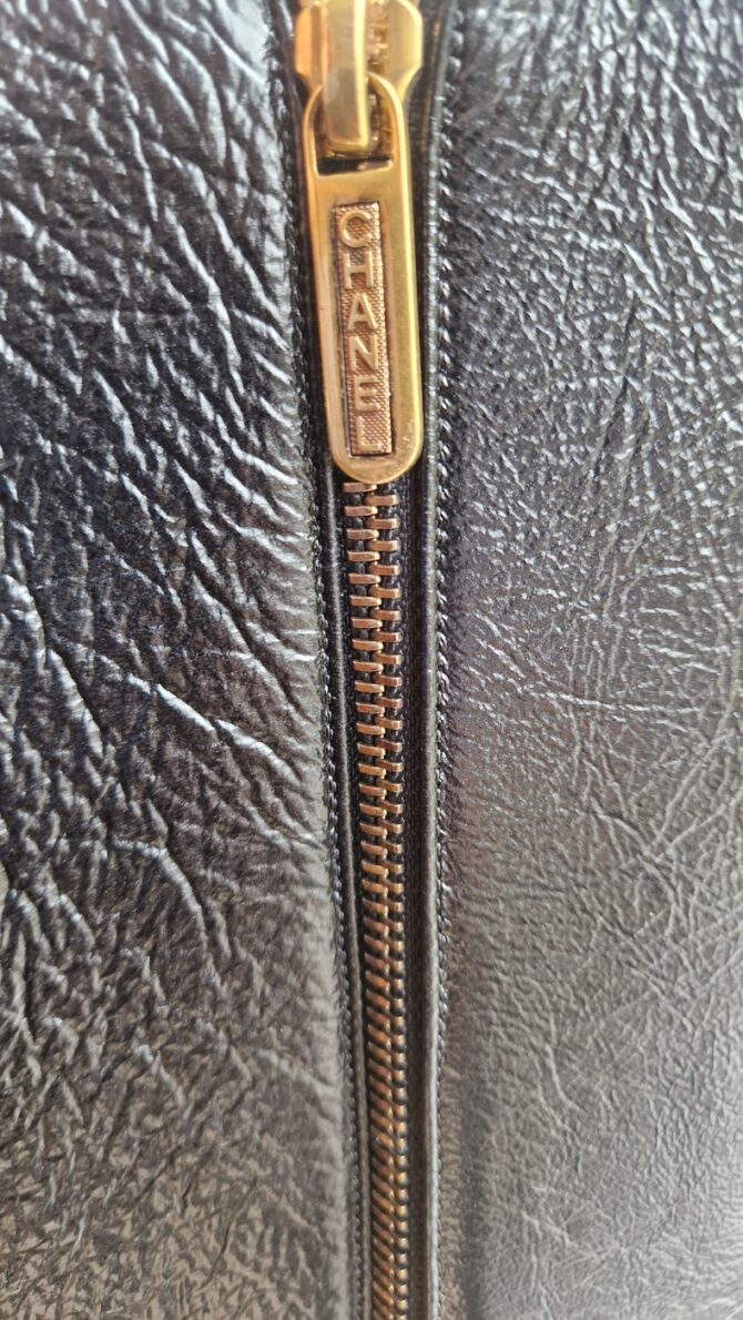 Détail de la fermeture éclair dorée gravée Chanel – Close-up of Chanel engraved gold zipper.