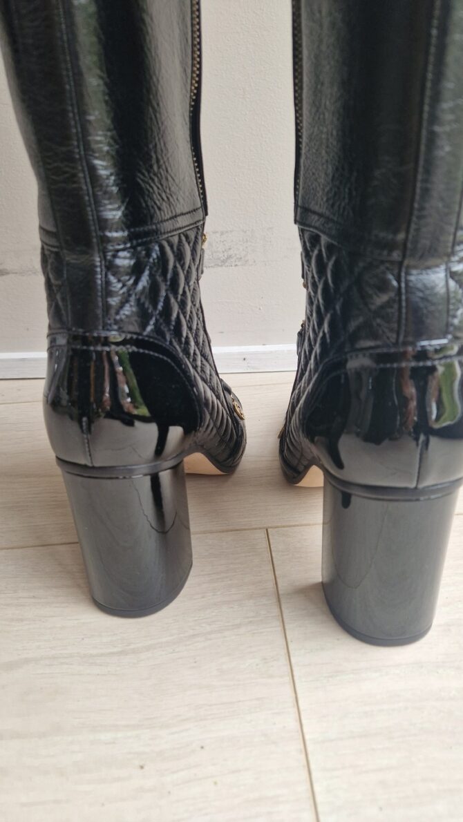 Vue arrière des talons en cuir verni noir – Back view of black patent leather block heels.