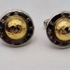 Boutons de manchette Céline or et argent vus de face, avec motif étoilé central.