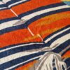 drap de bain Hermès représentant les parasols de deauville - zoom sur un parasol rayé bleu et orange