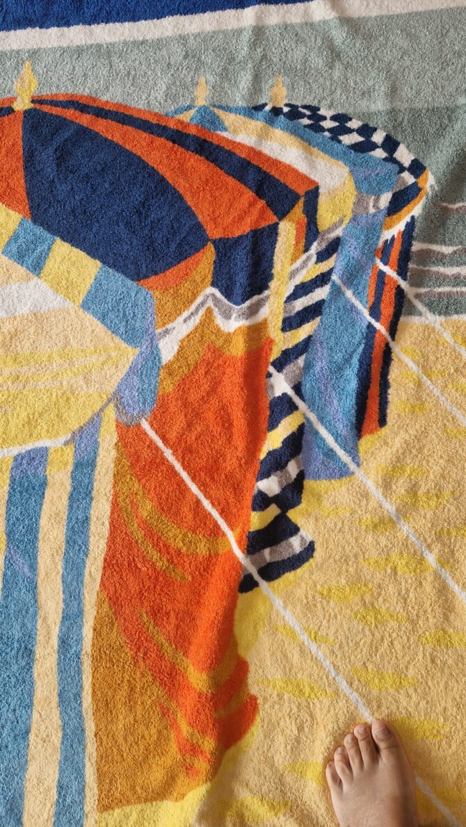 drap de bain Hermès représentant les parasols de deauville -détail des parasols alignés sur le sable avec bord de mer en arrière plan