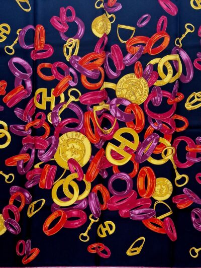 Carré Céline en soie, fond noir, motif anneaux multicolores, médaillons et détails équestres. EN : Céline silk scarf, black background, multicolored rings, medallions and equestrian details.