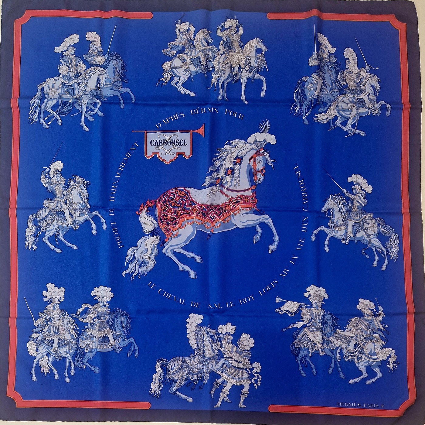Carré Hermès Carrousel par Christiane Vauzelles, édition 1984, vue d’ensemble sur fond bleu roi. EN : Hermès scarf Carrousel by Christiane Vauzelles, 1984 issue, full view on royal blue background.