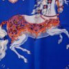Gros plan du cheval central richement harnaché et des cavaliers du carré Carrousel. EN : Close-up of the richly harnessed central horse and riders on Carrousel scarf.