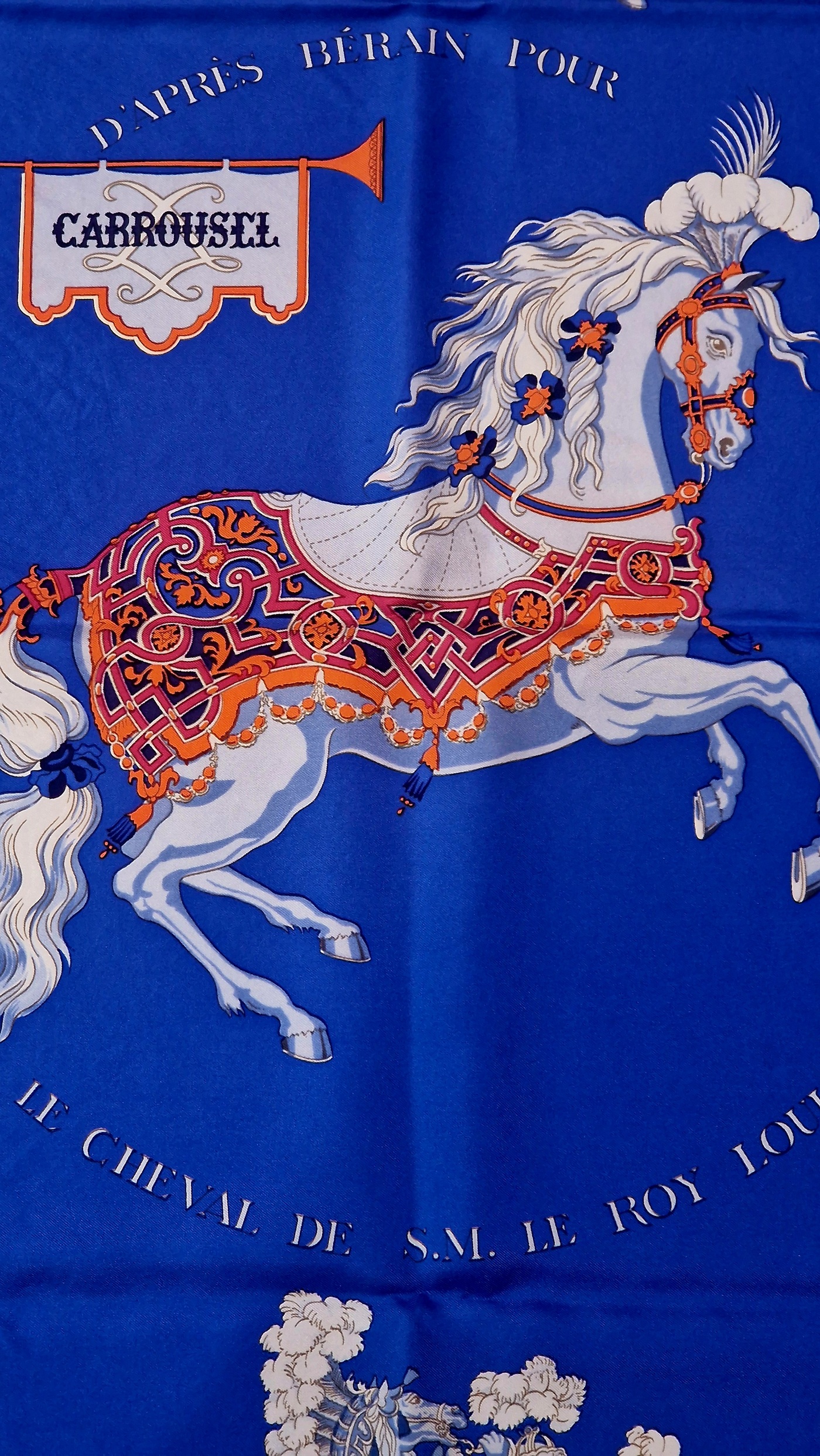 Gros plan du cheval central richement harnaché et des cavaliers du carré Carrousel. EN : Close-up of the richly harnessed central horse and riders on Carrousel scarf.