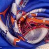 Gros plan sur la texture du twill de soie et les couleurs vives du carré Carrousel. EN : Close-up of silk twill texture and vibrant colors of Carrousel scarf.