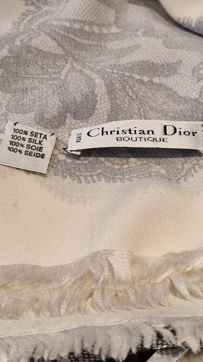 etiquette et frangeshâle Christian Dior porté , il est en soie ivoire avec motif floral noir façon dentelle Chantilly, circa 1988–1992