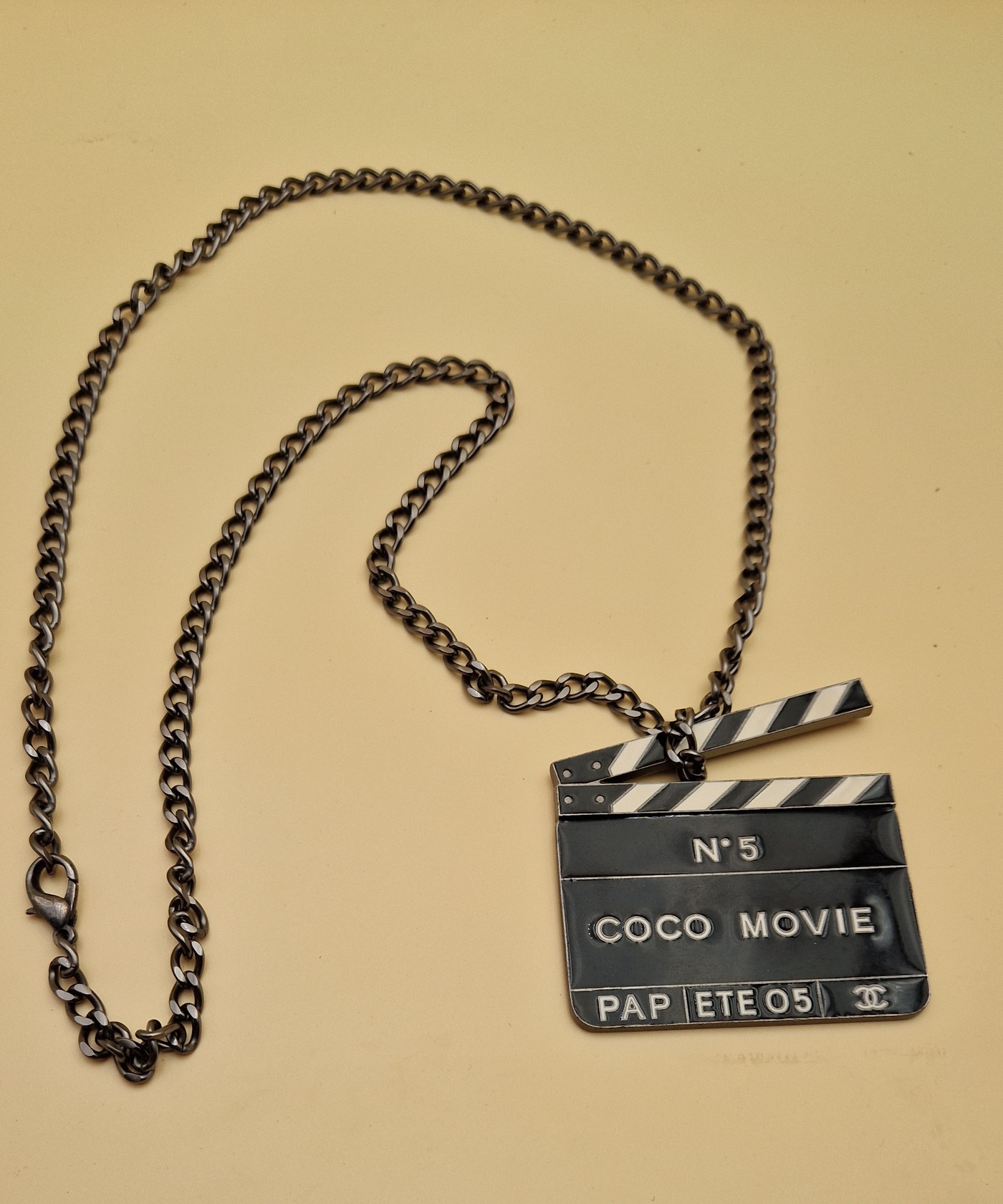 Pendentif Chanel “Coco Movie” en métal ruthénium et émail noir et blanc, collection Prêt-à-Porter Été 2005.