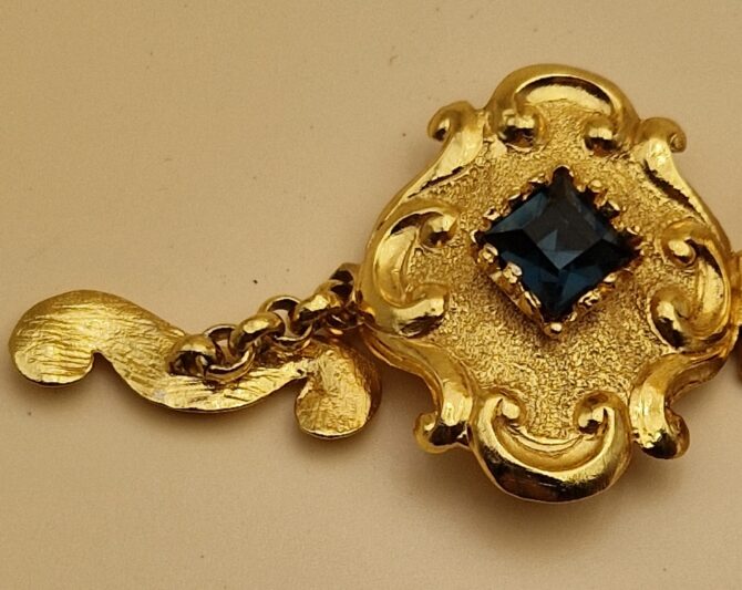 Bracelet Christian Lacroix doré baroque avec pierres rouges, bleues et ambrées, signé Made in France, dans sa boîte d’origine.