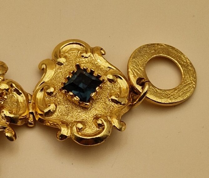 Bracelet Christian Lacroix doré baroque avec pierres rouges, bleues et ambrées, signé Made in France, dans sa boîte d’origine.