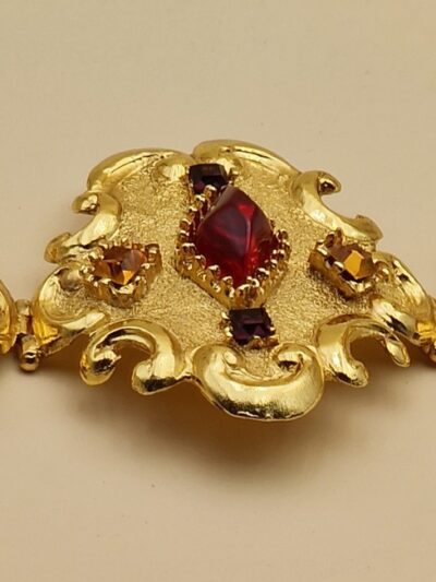 Bracelet Christian Lacroix doré baroque avec pierres rouges, bleues et ambrées, signé Made in France, dans sa boîte d’origine.