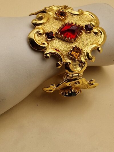 Bracelet Christian Lacroix doré baroque avec pierres rouges, bleues et ambrées, signé Made in France, dans sa boîte d’origine.