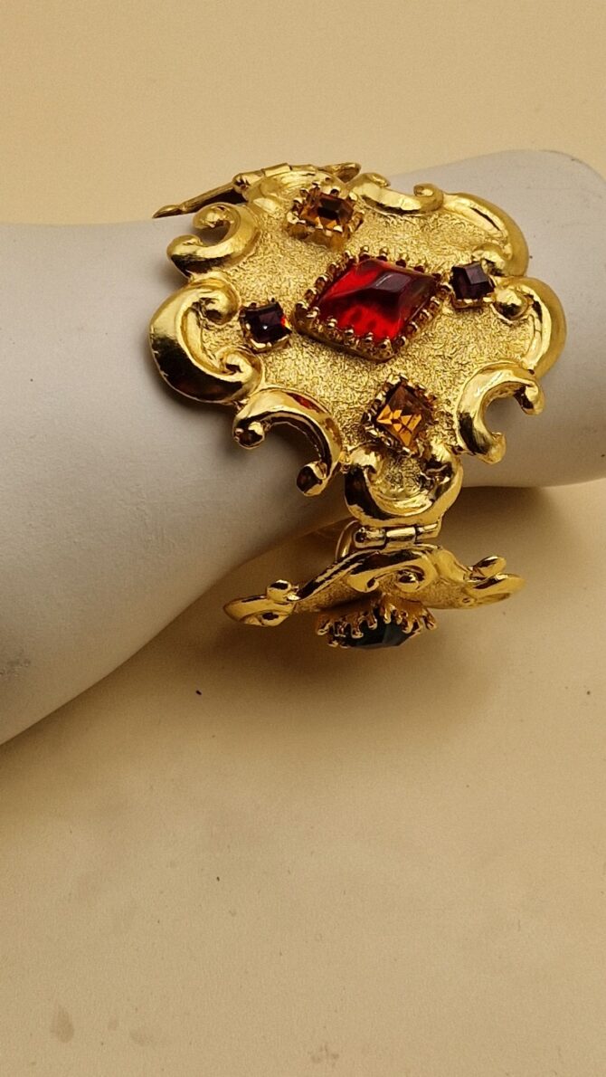 Bracelet Christian Lacroix doré baroque avec pierres rouges, bleues et ambrées, signé Made in France, dans sa boîte d’origine.