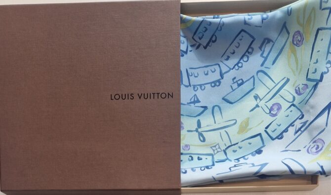 Carré Louis Vuitton en soie motif voyage avec avions, trains et bateaux sur fond bleu ciel boîte