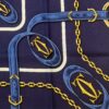 Carré Must de Cartier vintage 1990 en soie bleu marine à motif de sangles et chaînes dorées, état neuf.