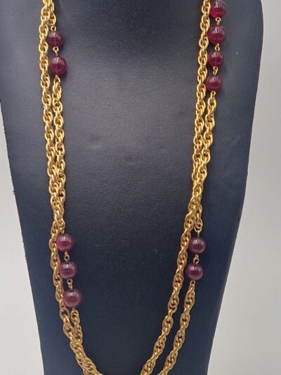 Collier Chanel vintage, sautoir deux rangs (1985) Ce collier est composé de chaînes dorées entrelacées et de  perles en pâte de verre rouge translucide